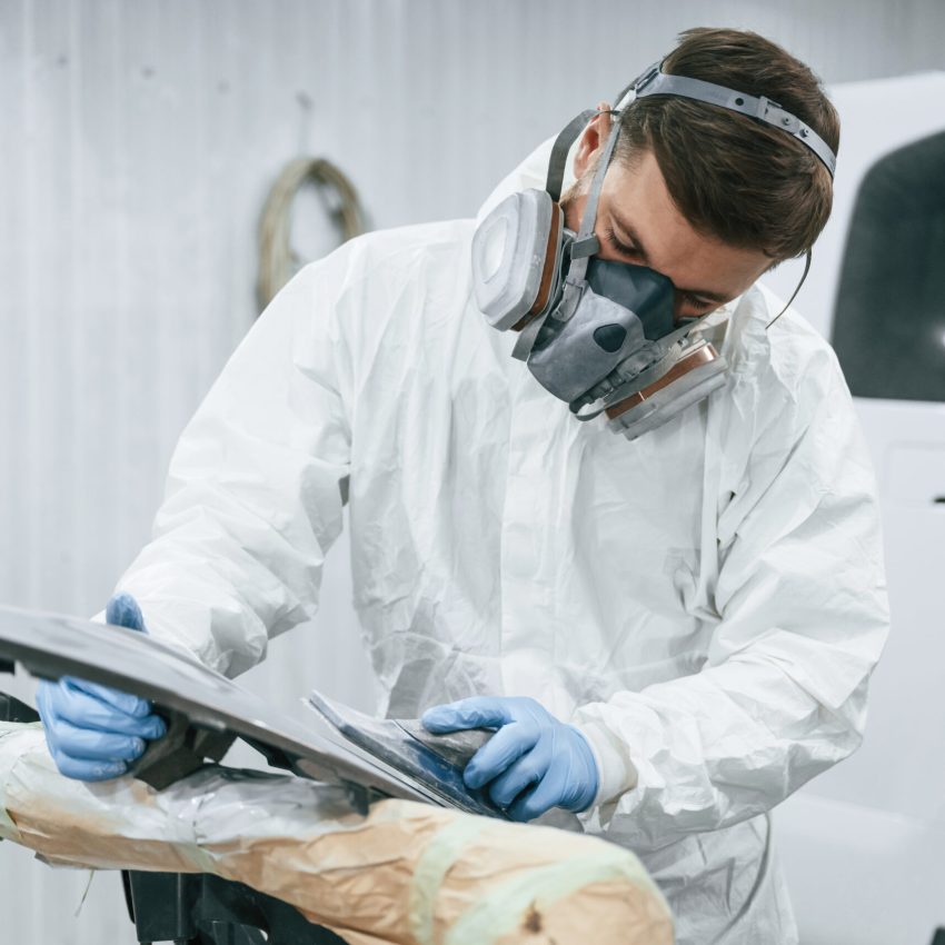 Metal carcass. Repairman is working in the garage.
